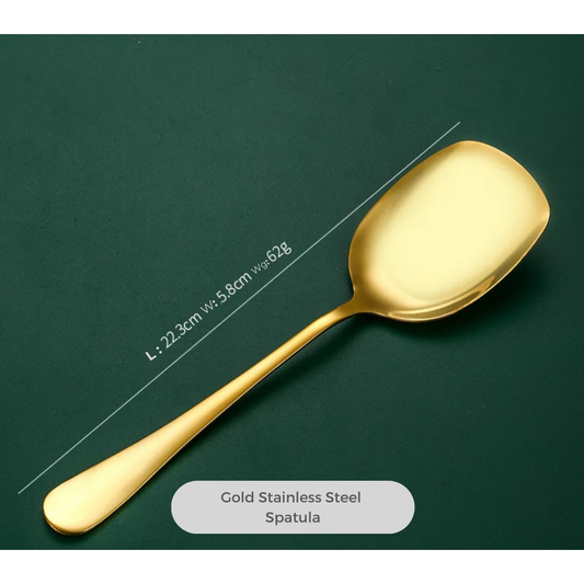 A gold-colored stainless steel spatula with a length of 22 cm, displayed on a dark background. The spatula has a glossy finish and a handle, with a label indicating 'Gold Stainless Steel - Spatula'.