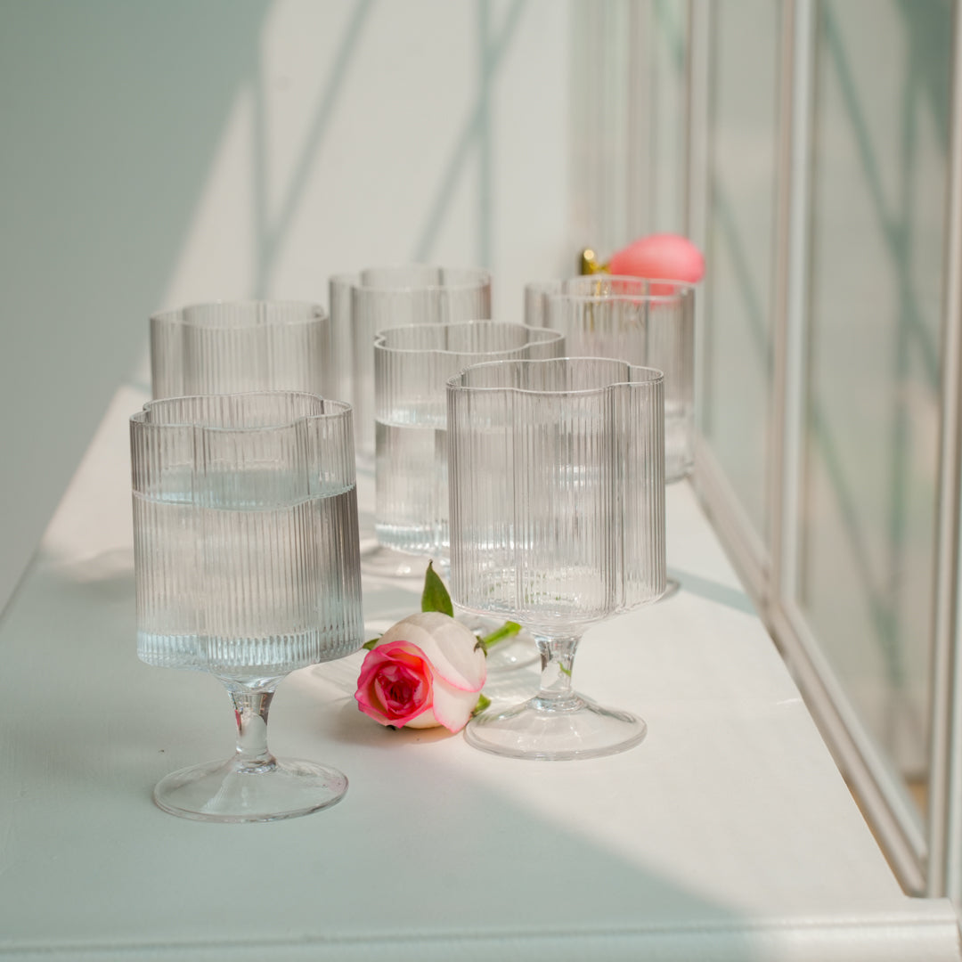 Clear glass tumblers with water on a white surface.