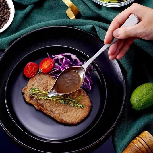 Chef-style plating tool drizzling chocolate sauce over pancake