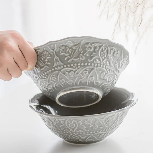 European embossed grey ceramic serving bowl with a floral pattern.