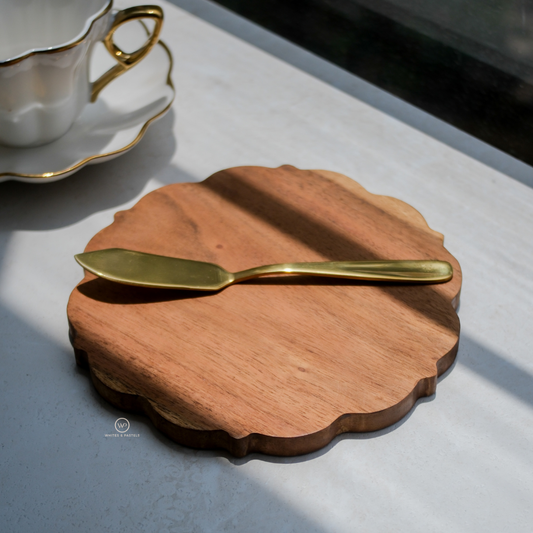 Scalloped edge charcuterie board placed on table with tea cup