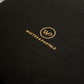 Close-up of a black textured surface with gold foil branding reading 'WHITES & PASTELS' and a circular 'WP' logo.