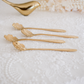 Designer gold spoons showcasing finely carved floral craftsmanship for luxury table décor and entertaining.
