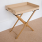 Side profile of a luxury beige butler tray featuring a decorative gold bird handle and premium folding stand.