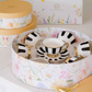 Stylish porcelain tea cup and saucer set featuring bold black stripes and gold detailing.