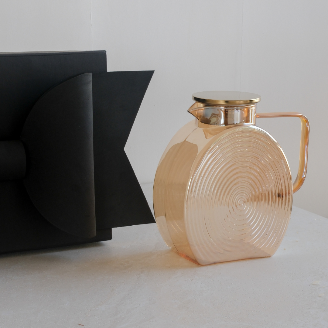Brown glass jug with gold lid and elegant handle displayed with a luxury black gift box