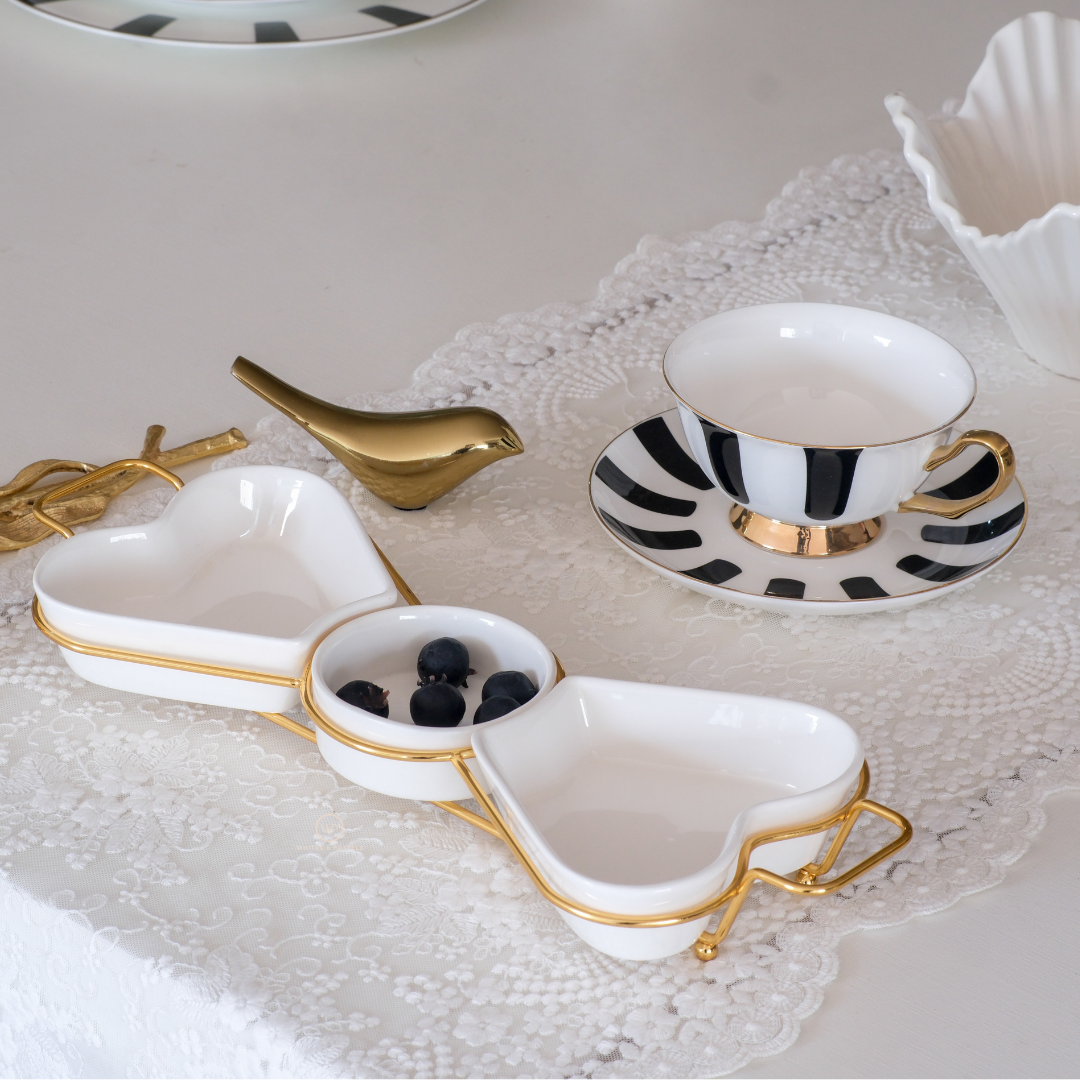 Heart shaped ceramic serving bowl set with decorative gold stand.