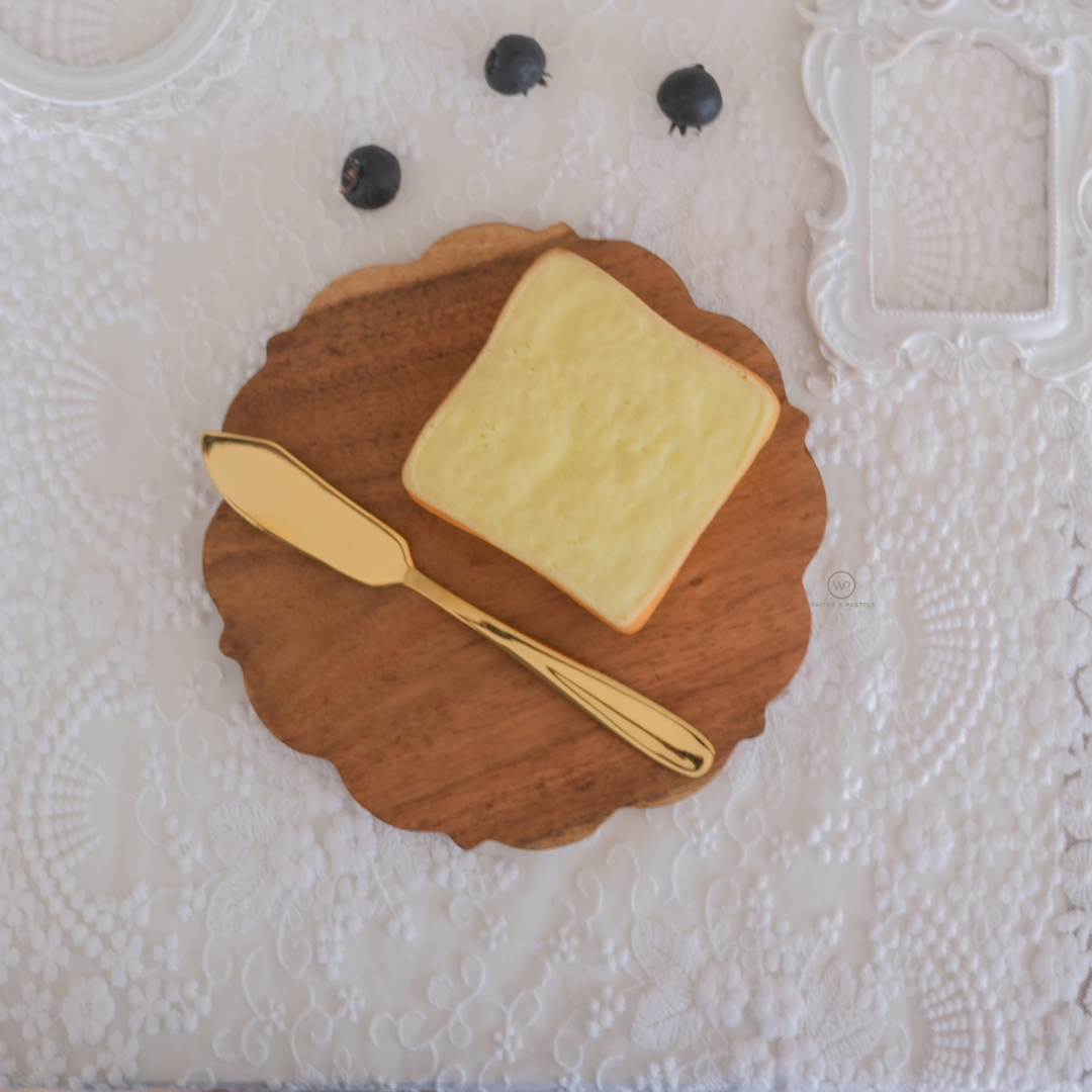A 7 inch compact charcuterie board placed on white runner with cheese block and olives