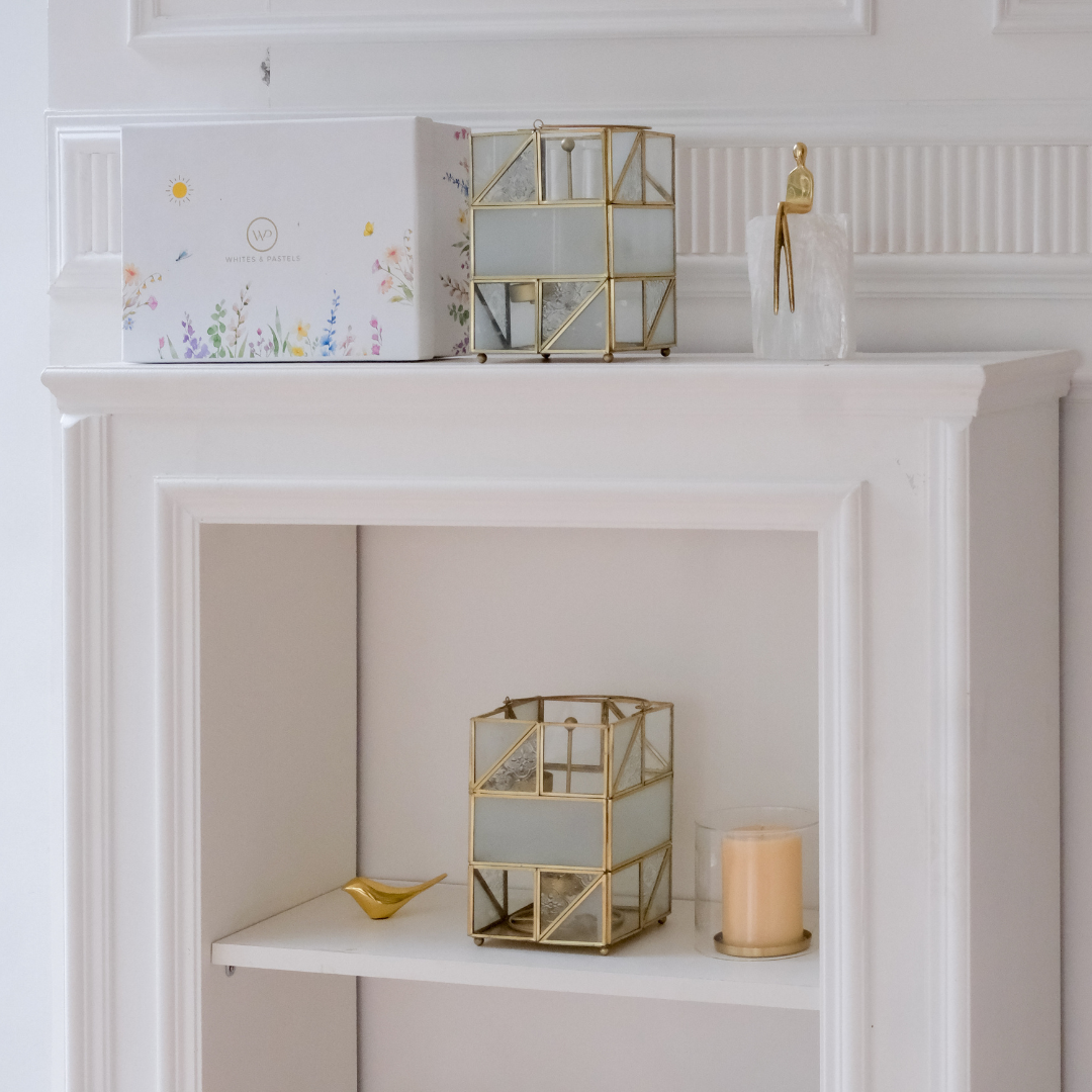 Contemporary gold lantern candle holder with artistic glass detailing for elegant interior decoration.