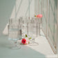 Clear glass tumblers with water on a white surface.