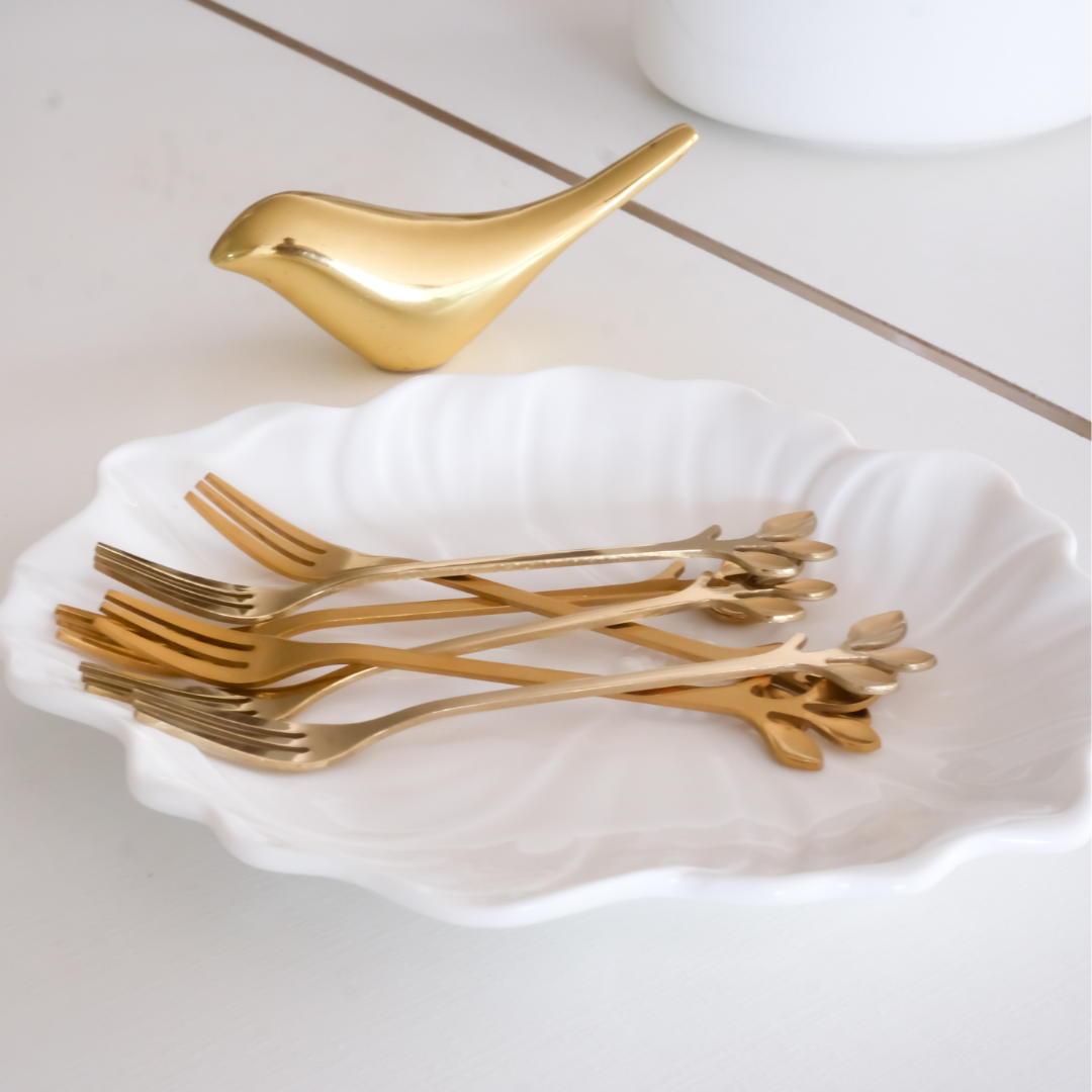 Decorative gold fruit forks with botanical leaf handles for modern table settings