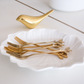 Decorative gold fruit forks with botanical leaf handles for modern table settings
