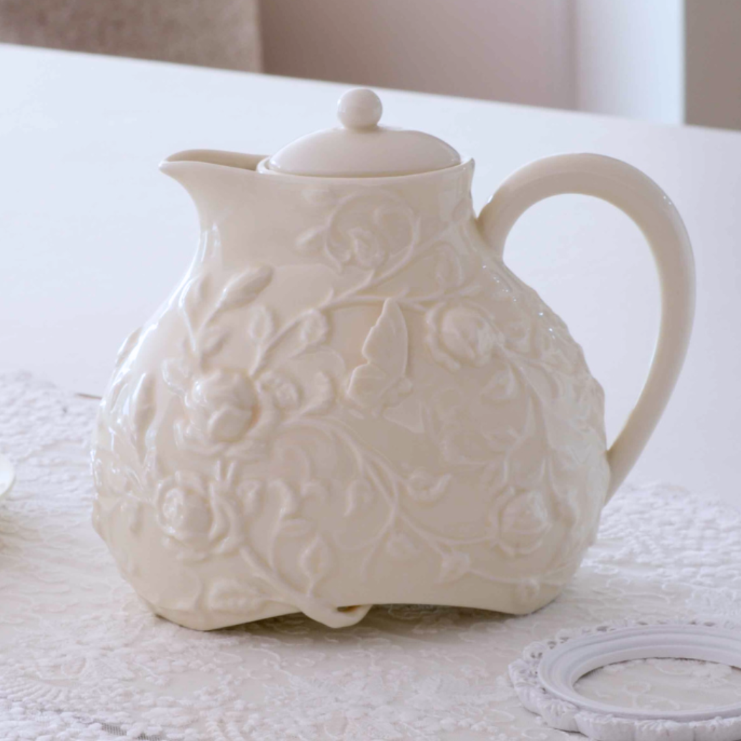 Decorative ivory ceramic tea pot with lid for serving tea