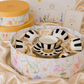 Modern striped porcelain tea cup and saucer set presented in elegant floral gift packaging.