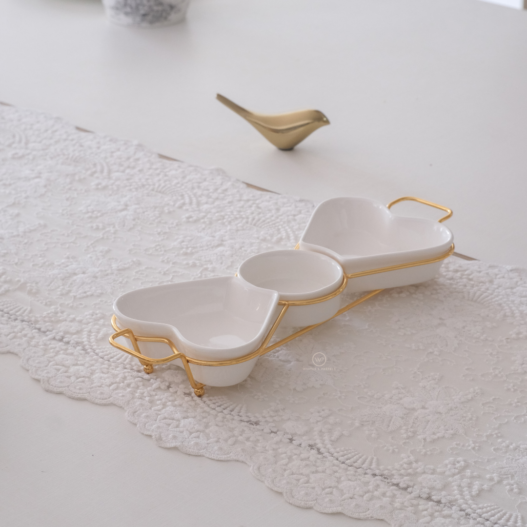 White ceramic serving platter with gold stand for entertaining guests.