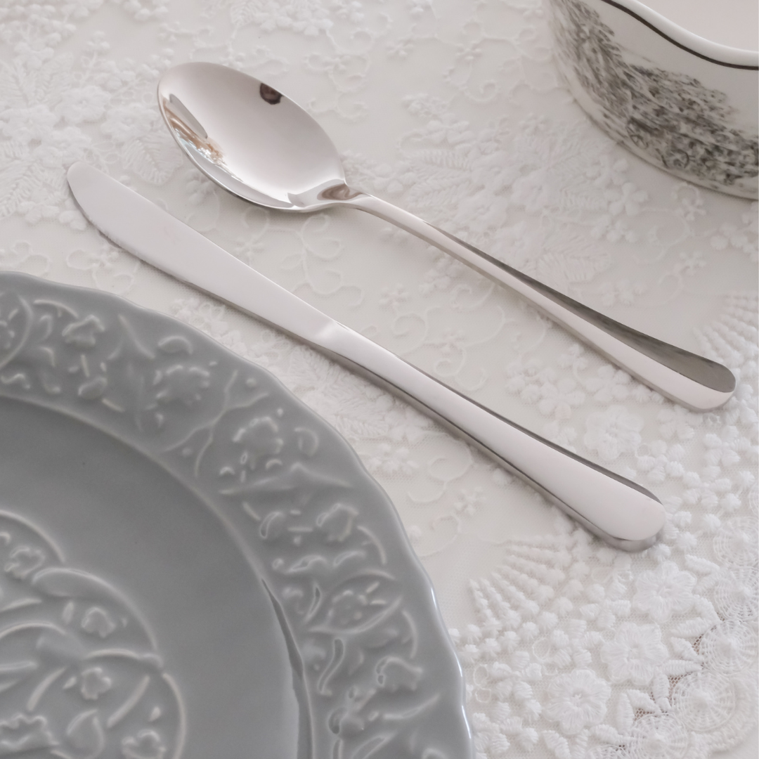 Spoon and knife placed on a white table mat