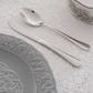 Spoon and knife placed on a white table mat