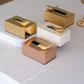Luxury metallic tissue box with decorative bird accent in gold, rose gold and ivory finishes displayed on an elegant tabletop