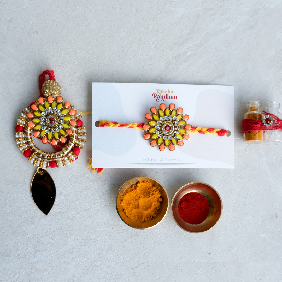 Bhai Bhabhi rakhi set featuring floral enamel design, crystal embellishments and elegant lumba for festive gifting.