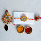 Bhai Bhabhi rakhi set featuring floral enamel design, crystal embellishments and elegant lumba for festive gifting.