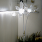 Floral standing lamp with realistic white petals and ambient glow.