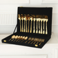 A gold-plated cutlery set with forks, spoons, and knives displayed inside an open black velvet presentation case on a white mantelpiece.