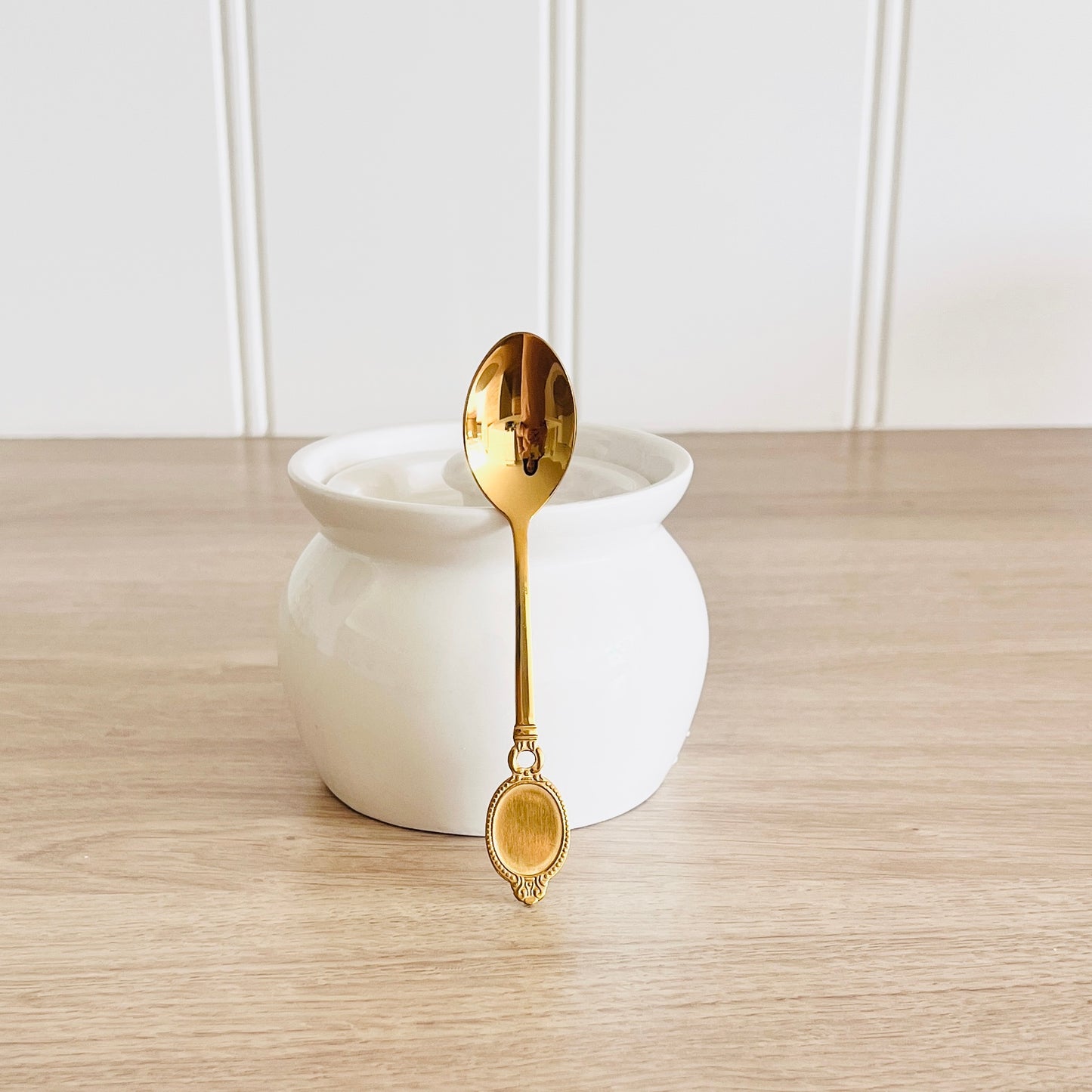 Elegant white ceramic container with gold spoon – modern Indian kitchen accessory