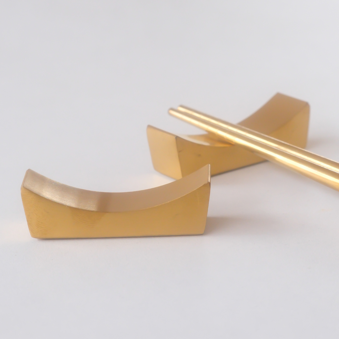 Gold chopstick rest on a white background