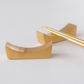 Gold chopstick rest on a white background