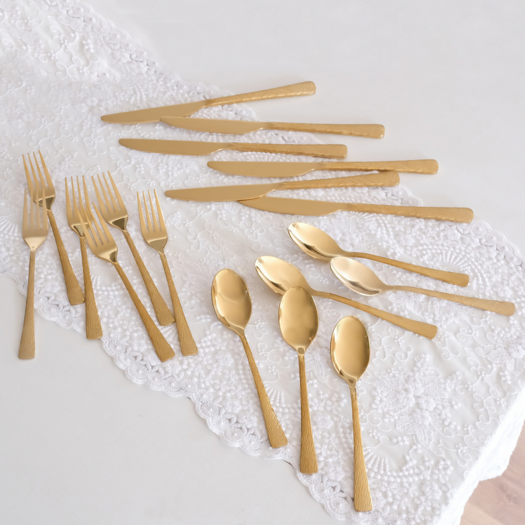 A 18 piece textured cutlery set placed on white runner