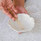 A lady holding a egg whisk over a bowl