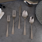 Luxury flatware set styled on a dining table with elegant ceramic plates and modern décor.