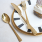 Gold textured spoon, fork, and knife set paired with a luxury dessert  for an elegant serving presentation.