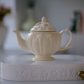 Premium ivory porcelain tea pot with intricate Victorian embossing and 1.2L capacity for elegant tea service.
