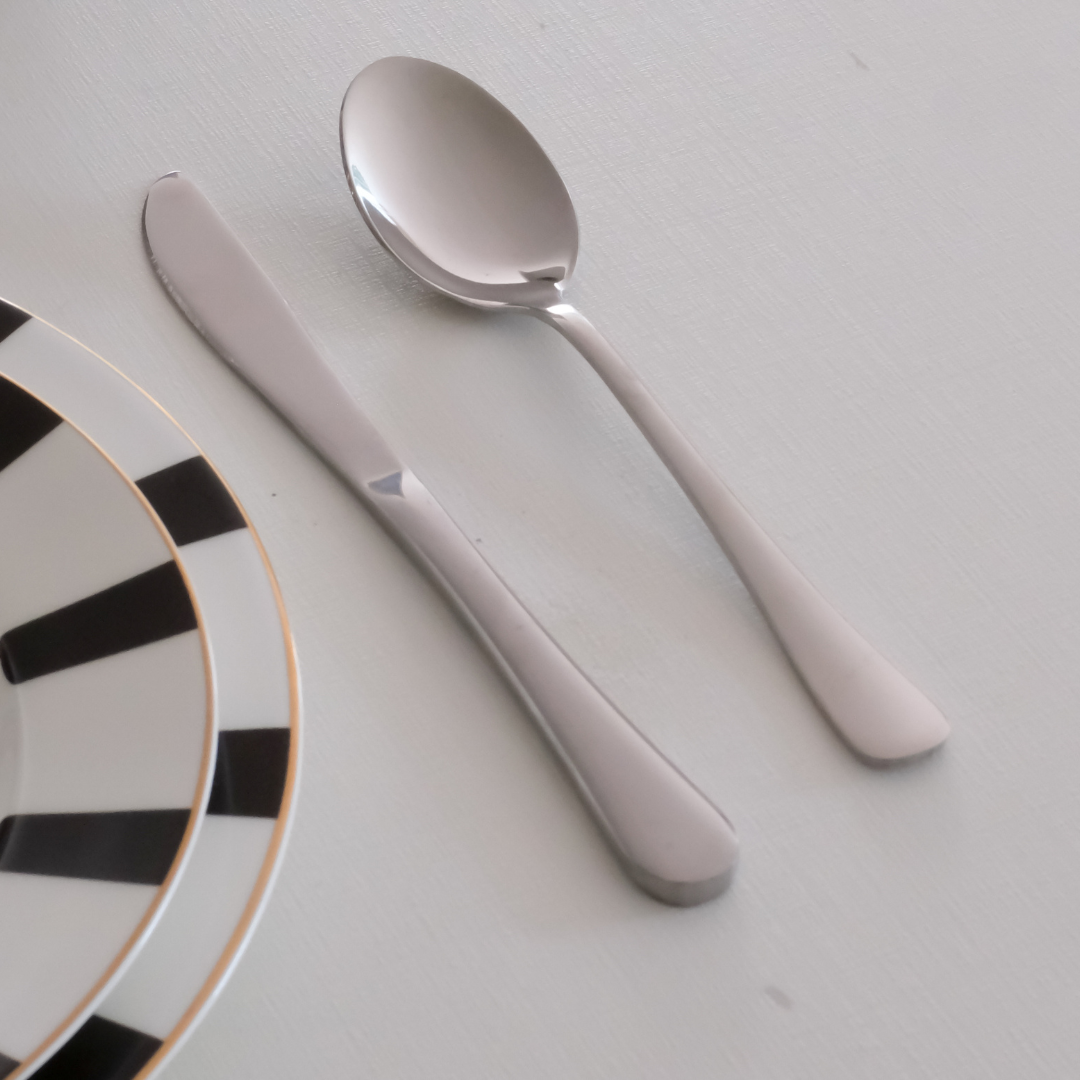 Stainless steel dining essentials including spoon, fork and knife for contemporary table settings.