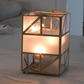 Modern geometric glass lantern with gold metal frame for tabletop décor.