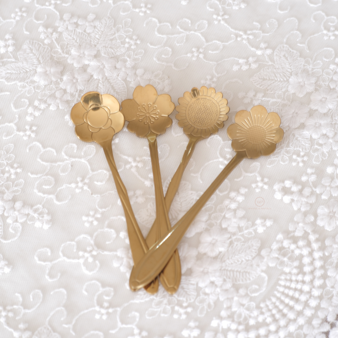 Set of designer floral spoons with intricately carved blossom-shaped bowls and sleek handles.