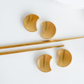 Set of gold steel spoons and chopstick rest on a white background