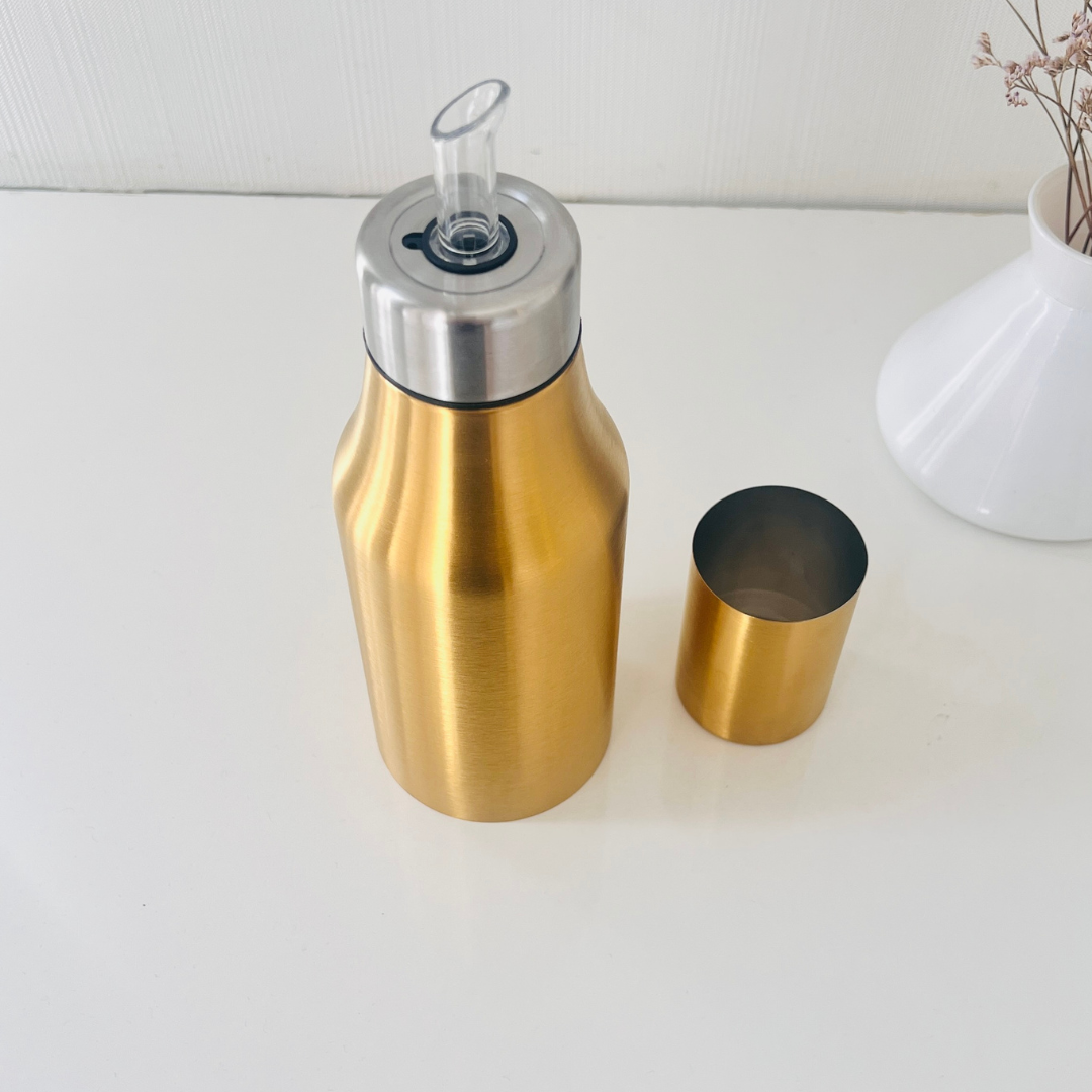 Close-up of gold oil bottle with spout - Whites & Pastels