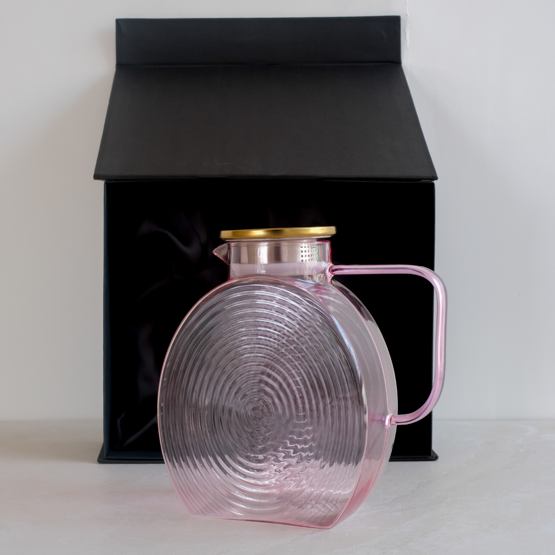 Pink glass serving jug with gold lid and sleek handle for stylish beverage serving