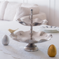 Modern tabletop serving stand with dual-tier design and sculptural detailing.