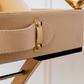 Close-up of the premium leather handle and gold hardware on a luxury beige serving tray.