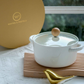 Elegant white ceramic serving pot with transparent glass lid and natural wooden knob, ideal for serving curries, soups and pasta in modern dining settings.