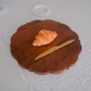 A Croissant on cutting board with Dinner Knife
