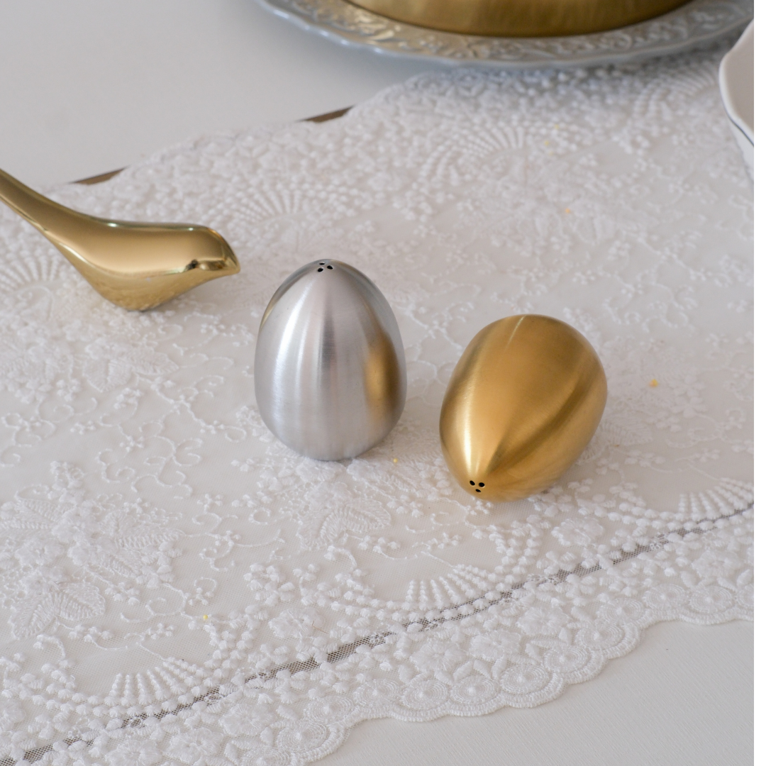 Modern serveware accessory featuring sculptural salt and pepper shakers.