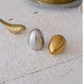 Modern serveware accessory featuring sculptural salt and pepper shakers.