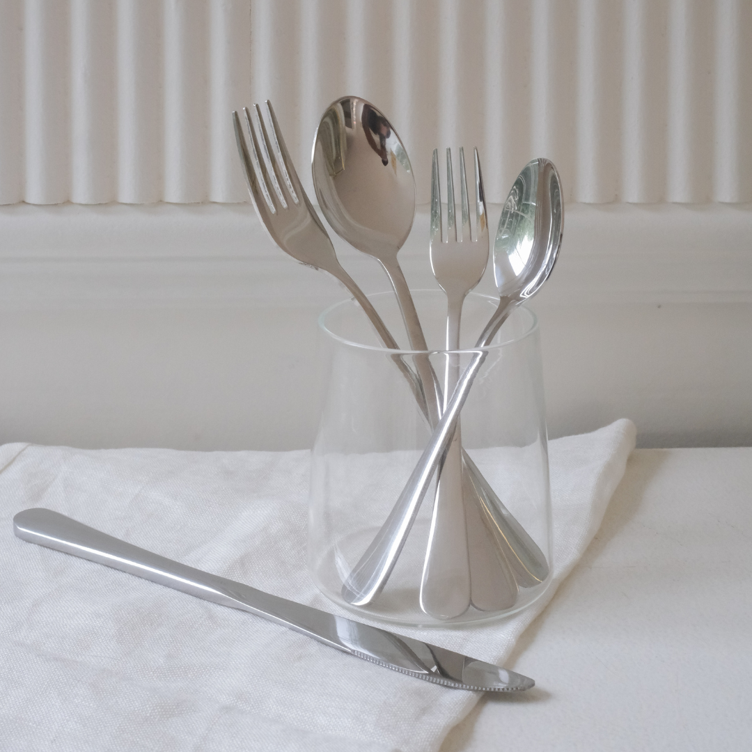 Luxury stainless steel flatware set styled with elegant dinnerware for contemporary dining.