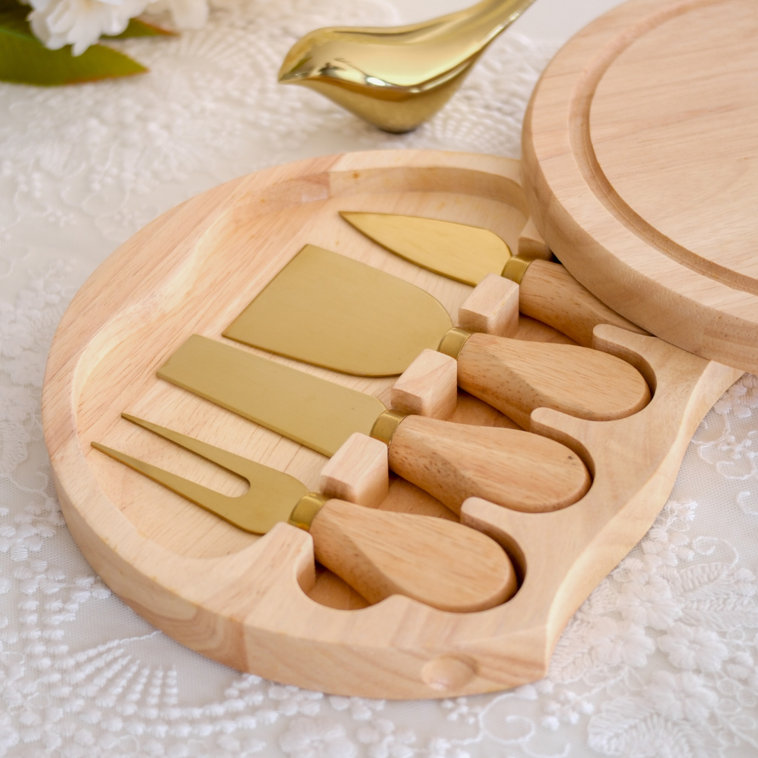Decorative wooden cheese serving board with four-piece cheese knife set.