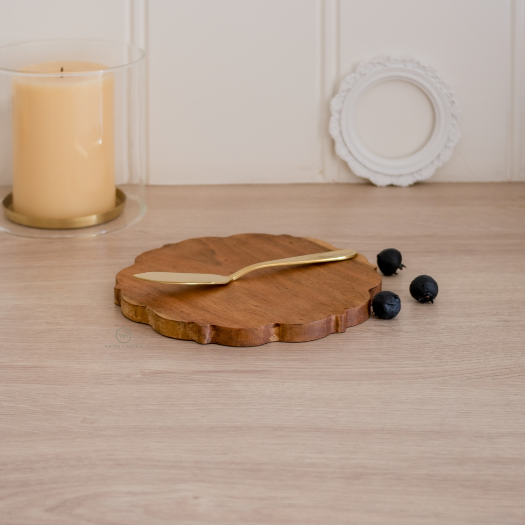 Round wooden board with a gold knife for serving cheese and dips
