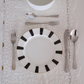 Stainless steel dinner cutlery set with spoon, fork and knife arranged on a decorative grey ceramic dinner plate